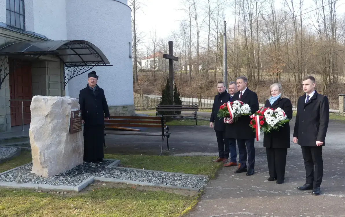Zdjęcie, widać na nim pomnik, kapłana i delegacje osób 