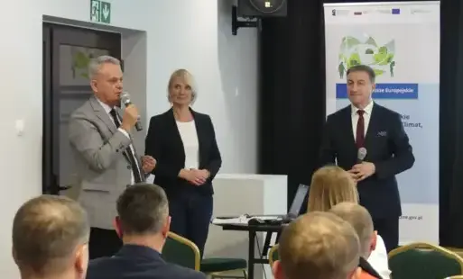 Na zdjęciu widac trzy osoby na spotkaniu 